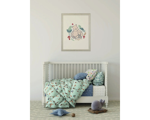 Kinderzimmer mit Babybett, Bettwäsche und einem Bild von Winnie Puuh an der Wand