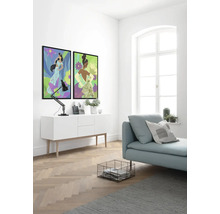 Heller Raum mit zwei gerahmten Wandbildern, einer Kommode, einer Lampe, einer Couch, einem Korb und einem Teppich.