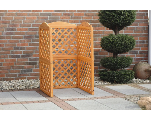 Paravent d''intimité en bois clair avec motif losanges devant un mur en briques