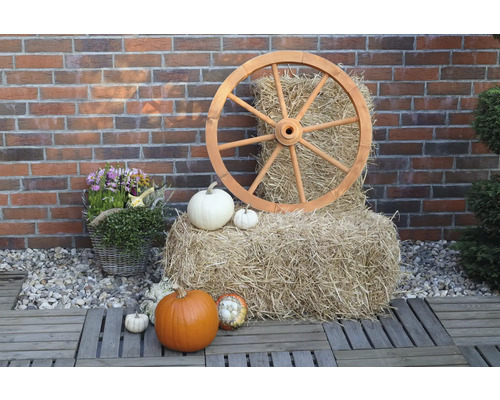 Dekorative Gartenszene mit Holzrad, Heuballen und Kürbissen