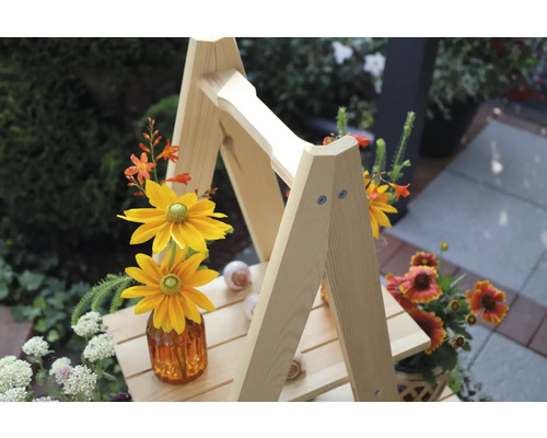 Dekorative Holzleiter mit Blumenarrangements im Aussenbereich.