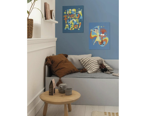 Kinderzimmer mit Bett, Kissen, Tisch und Wanddekoration