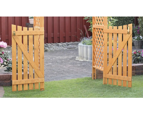 Portail en bois ouvert avec treillis dans un paysage de jardin
