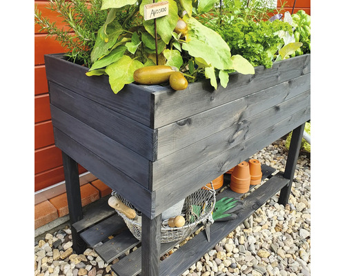 Jardinière sur pieds en bois avec plantes et accessoires de jardin