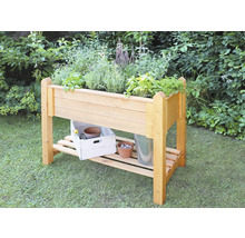 Hochbeet aus Holz mit Kräutern und Ablagefläche für Gartengeräte im Garten
