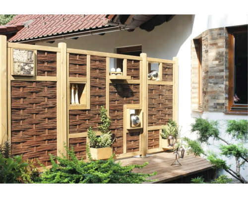 Sichtschutzzaun aus Holz und Weide mit Dekorationselementen im Garten