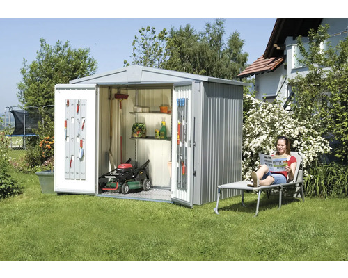 Metall Gerätehaus mit geöffneten Türen, Rasenmäher und Gartenwerkzeugen im Garten