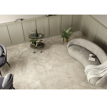 Pièce lumineuse avec carrelage imitation marbre, canapé, chariot de bar et plante d''intérieur.