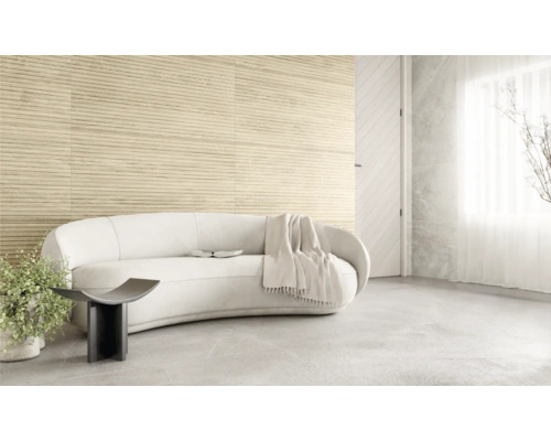 Pièce claire avec canapé, table d''appoint et carrelage mural imitation bois.