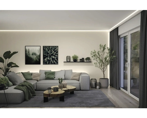 Wohnzimmer mit Sofa, Couchtisch, Pflanzen und Dekoration unter indirekter Beleuchtung