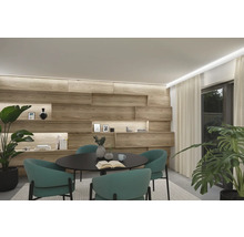 Helles Interieur mit Holzwand, rundem Tisch und grünen Stühlen
