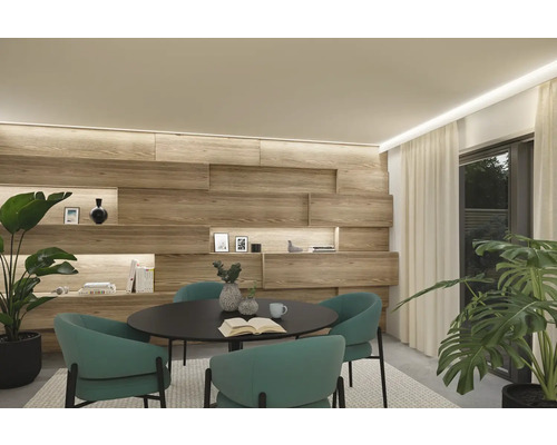 Heller Raum mit Holzwand, runder Tisch mit Stühlen und Zimmerpflanzen