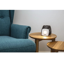 Salon avec fauteuil et lampe de luminothérapie sur une table d'appoint
