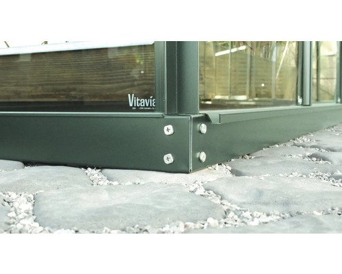 Vue détaillée d''une fondation de serre avec vis et logo Vitavia