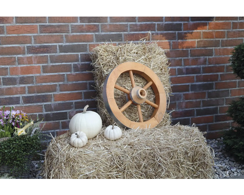 Roue de charrette petit modèle en bois Ø 50 cm h 14,5 cm couleur miel Décoration avec roue en bois, bottes de foin et citrouilles devant un mur de briques