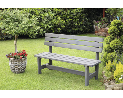 Banc de jardin en bois gris sur gazon avec plantes