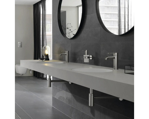 Salle de bains moderne avec double vasque, robinets, miroirs ronds et carrelage gris