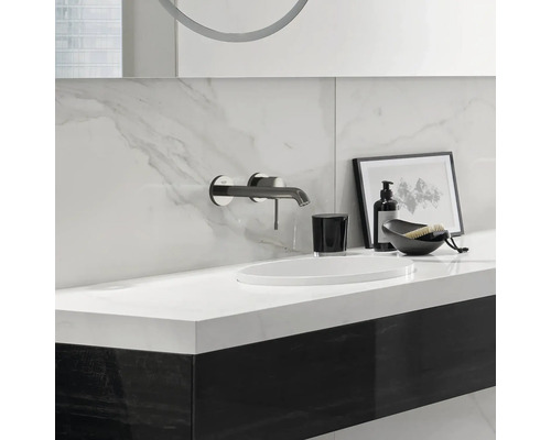 Modernes Badezimmer mit Waschtisch, Armatur, Seifenspender und dekorativen Elementen.