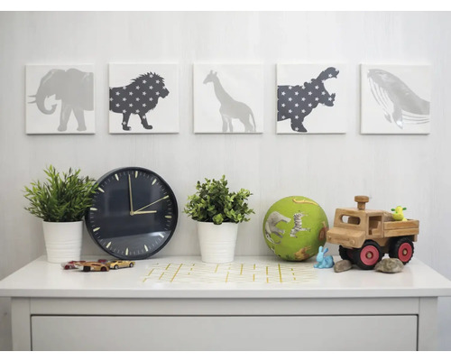 Chambre d''enfant décorative avec motifs d''animaux, horloge, plantes et jouets sur une table blanche
