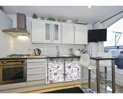 Cuisine lumineuse avec armoires blanches, appareils en acier inoxydable et une table à manger avec tabourets de bar.