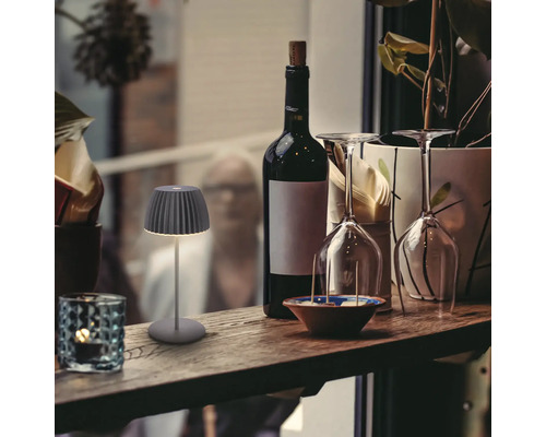 Lampe de table décorative à côté d''une bouteille de vin et de verres sur une étagère