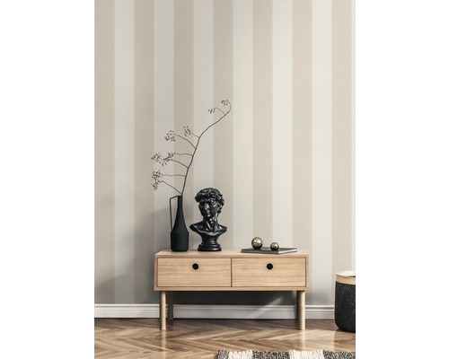 Dekoratives Wohnzimmer mit gestreifter Tapete, Kommode aus Holz, Vase, Kopf-Skulptur und Dekoration