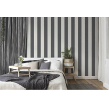 Chambre à coucher avec lit, table de chevet et papier peint rayé