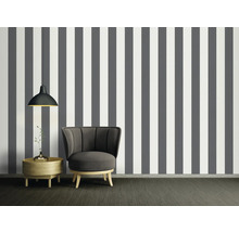 Vue d''une pièce avec papier peint rayé gris et blanc, fauteuil, table d''appoint et suspension