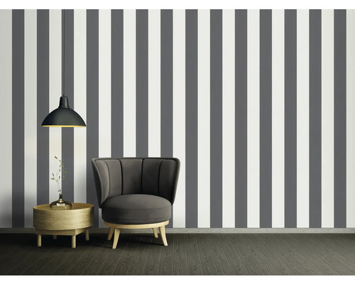 Vue d''une pièce avec papier peint rayé gris et blanc, fauteuil, table d''appoint et suspension