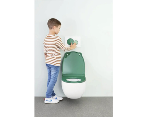 Enfant à des toilettes avec lunette de toilette verte et plaque de commande