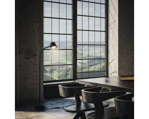 Intérieur avec table à manger, chaises et lampadaire devant une grande fenêtre avec vue sur le paysage