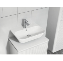 Modernes Badezimmerwaschbecken mit Armatur auf einem Waschtisch mit Rillenstruktur.