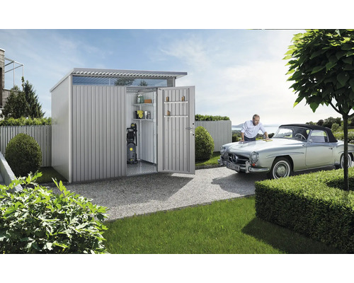 Metall Gartenhaus mit geöffneten Türen und Mann, der ein Auto putzt