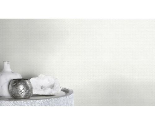 Dekorative Elemente auf einem Tisch vor einer Wand mit dreieckigem Muster