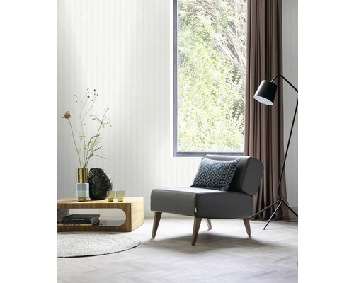 Wohnzimmer mit Sessel, Tisch, Stehlampe und Fenster