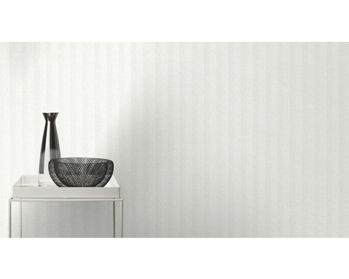 Helle Wand mit Tapete, darauf eine Vase und eine Schale auf einem Tisch
