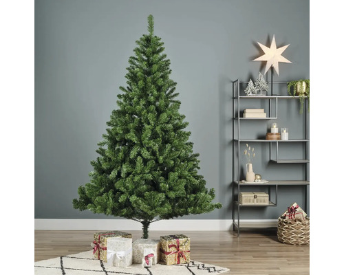 Künstlicher grüner Weihnachtsbaum mit Geschenken im Wohnzimmer.