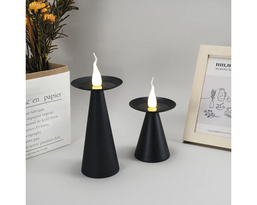 Zwei schwarze Kerzenleuchten mit LED-Kerzen auf einem Tisch