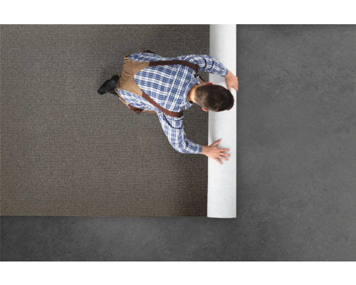 Homme déroulant un tapis