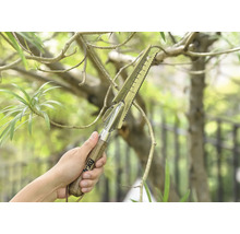 Une main tient un outil de jardin multifonctionnel avec un manche en bois