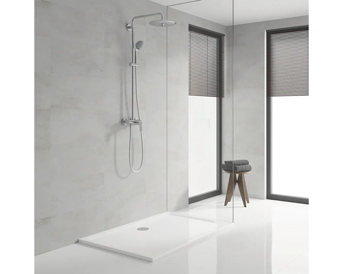 Salle de bains moderne avec receveur de douche, robinetterie de douche et deux fenêtres avec stores.