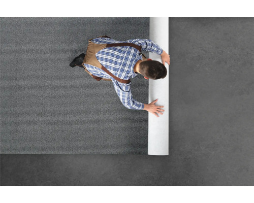 Homme déroulant une moquette grise