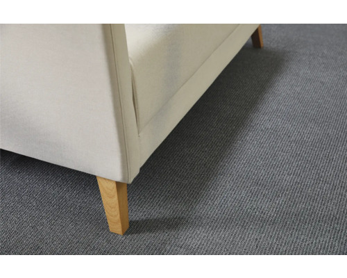 Vue détaillée d''un fauteuil rembourré avec revêtement en tissu et pieds en bois sur un tapis