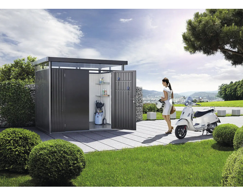Szene mit einem modernen Geräteschuppen aus Metall, einer Frau und einem Roller im Garten.