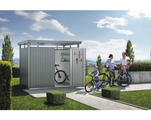 Familie vor einem Fahrradschuppen mit Fahrrädern und Gartenzubehör