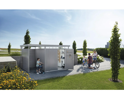 Familie mit Fahrrädern und Rollern vor Gerätehaus im Garten.