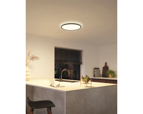 Eine moderne Küche mit einer runden Deckenleuchte, die für eine helle und einladende Atmosphäre sorgt.