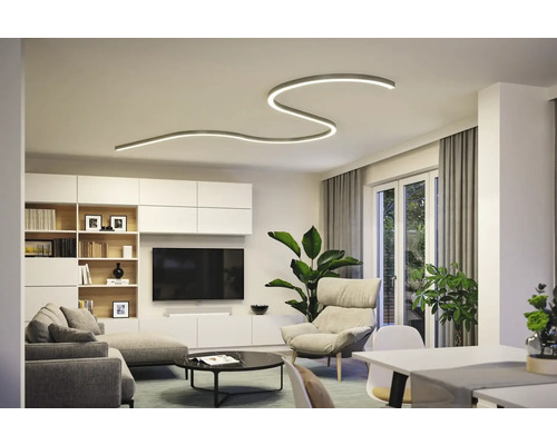 Wohnzimmer mit moderner Deckenleuchte, Sofa, Sessel und TV-Wand.