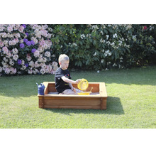 Garçon jouant avec des jouets de sable dans un bac à sable dans le jardin.