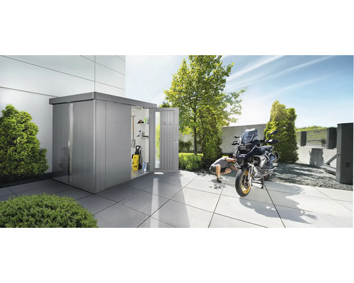 Metall Gerätehaus mit geöffneter Tür, Motorrad und Mann bei Reparaturarbeiten im Garten